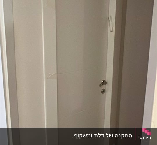 דלת לבנה עם ידית כסופה בחדר פנימי